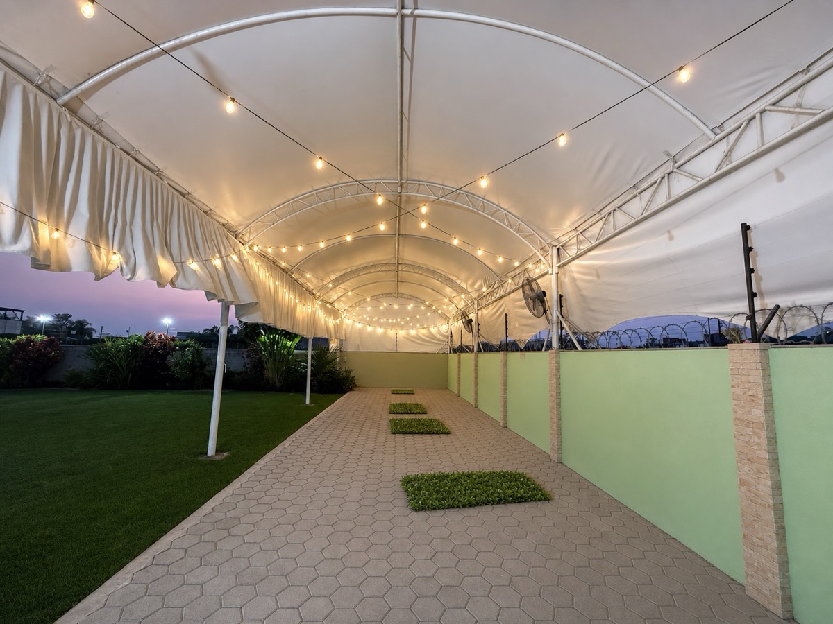 Pasillo bajo carpa con piso adoquinado y luces de evento